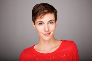 Young woman wearing a red jumper with a pixie cut